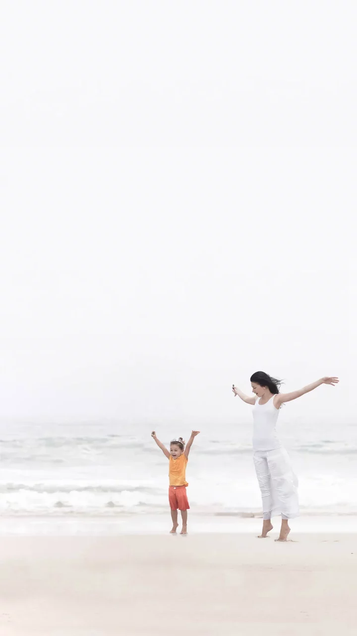 Mother and daughter enjoy optimal health eternal happiness at beach after healthy colon cleanse